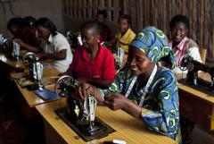 a group of women seated at tables with sewiing machines