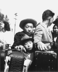 2 young boys and a man with suitcases