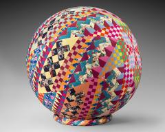 A colorful 3-D quilt in the shape of a sphere. Many different patchwork designs.