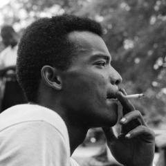 Black and white profile photo of Herbert Randall. He is looking to the right of the camera and holding a cigarette to his mouth.