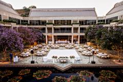 An outdoor courtyard with a lily pond decorated with lights, tables, and a dance floor.