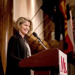 Katherine Spillar standing beside a microphone and podium.