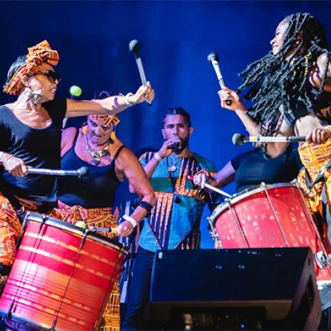 Musicians playing drums and holding a microphone