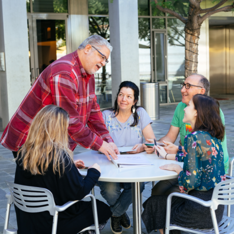 men and women gathered around a table having a discussion