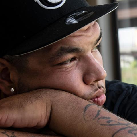 close-up of a young man in a baseball cap staring off into distance