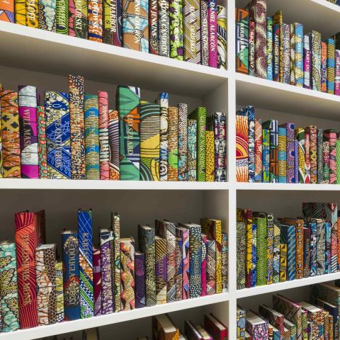 Close up view of colorful books on white shelves