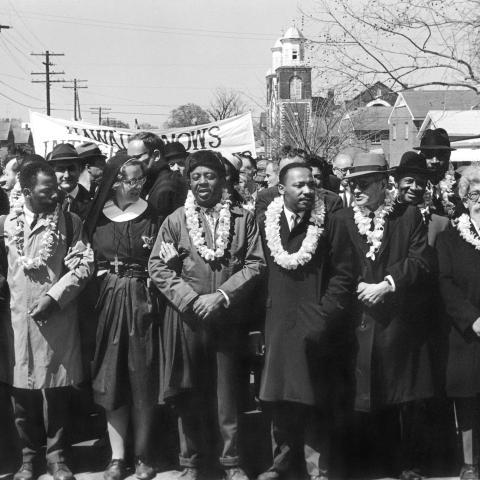 A row of people lead marchers