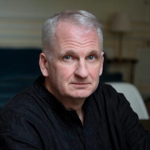 Headshot of Timothy Snyder looking at the camera in a black shirt. To the left is the cover of the book, On Freedom.