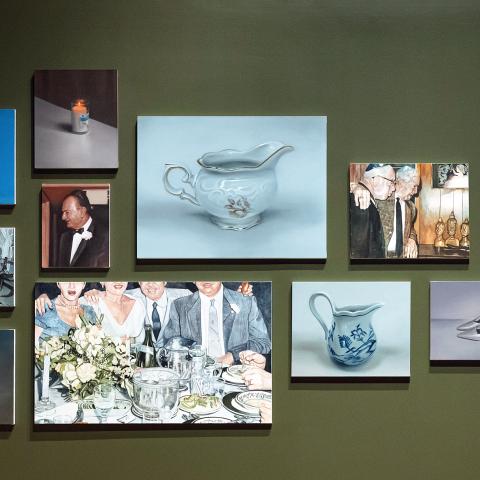 A group of painting hung together in a gallery featuring everyday life and objects.