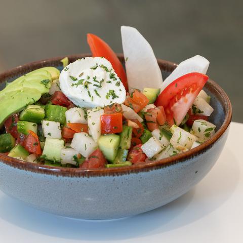 A big colorful salad in a ceramic bowl