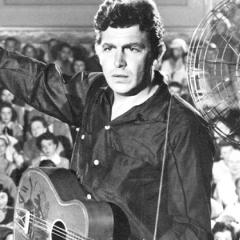 Black and white still from the movie showing the main character on stage in front of a large crowd of fans