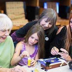 3 women and a young girl making art