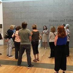 Group of people listening to a docent at the entrance to the Visions and Values exhibition