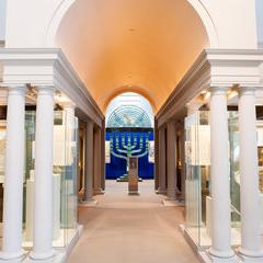 view of Visions and Values exhibition with large menorah at the end of a long arched walkway