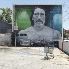 mural on the side of a building showing a bust of a man with a mustache