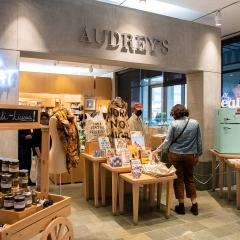 Image of the museum store with Audrey's sign in big letters with woman shopping