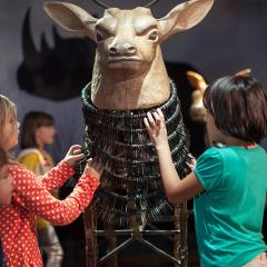 children with a sculpture of a deer with antlers