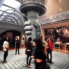 people viewing large-scale model of Statue of Liberty hand and torch