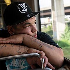 a young man in a baseball cap looking out a window