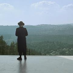 Hasidic Jew and a man and woman holding each other at Yad Vashem