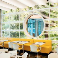 Image inside Zeidler's cafe with yellow booths and white tables