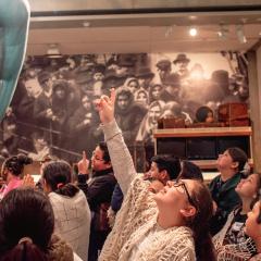 A group of school children looking up at the statue of liberty hand in the Vision and Values gallery