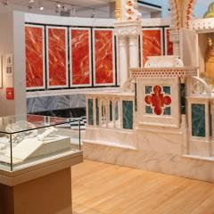 A women looking at case with objects in it in a large gallery.