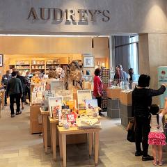 A store setting with books and gift with many people browsing.