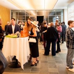 People gather in Ruby Commons at the Skirball talking amongst themselves with refreshments.