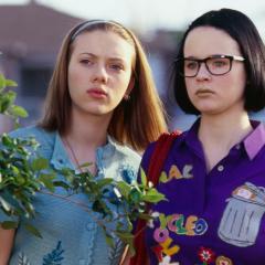 Still from the film Ghost World showing Scarlett Johansson and Thora Birch standing side by side looking at something off camera.