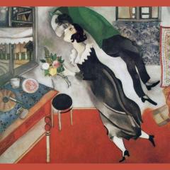 Chagall painting, The Birthday, depicting a woman in a black dress holding a bouquet of flowers in a living room. A figure in green wraps around the woman seemingly about to kiss her. On the right is the painting, Woman with Red Hair, by Modigliani of a woman in a dark dressing sitting on a light blue background.