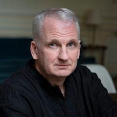 Headshot of Timothy Snyder looking at the camera in a black shirt. To the left is the cover of the book, On Freedom.