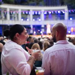 A man and a woman talking to each other waiting for an outdoor performance.