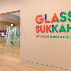 The entrance to the Glass Sukkah exhibition with the sukkah appearing through the entryway.