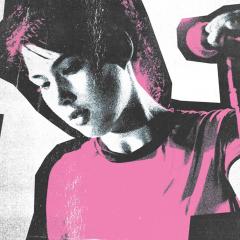 A woman standing in front of a microphone holding it next to the words The Punk Singer in script.