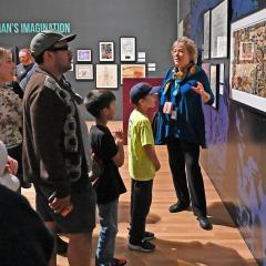 A teacher talked to a school group about comic books as they listen to her.