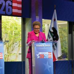 Three mayor candidates stand at individual podiums that read decision 2026.
