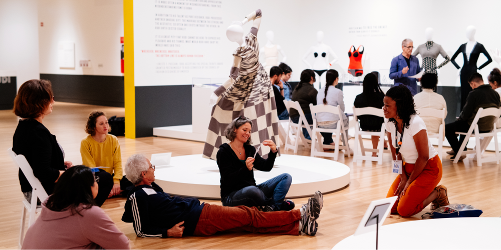 people sitting on the floor and in chairs having a discussing