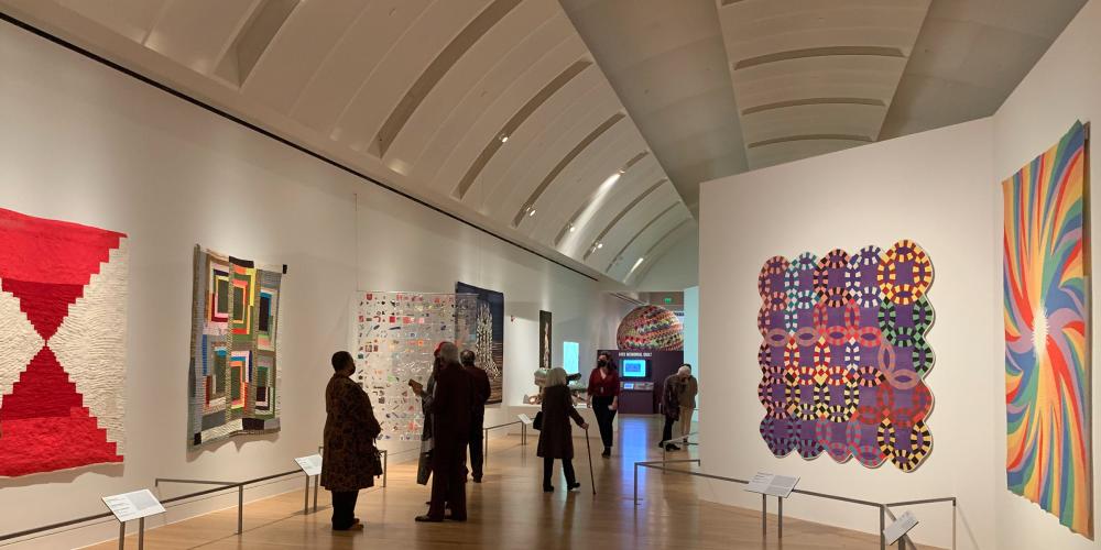 Installation photo of Fabric of Nation exhibition with visitors in gallery