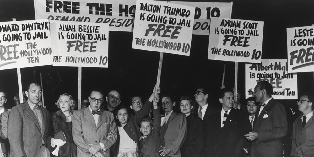 A black and white photo of a group of protesters with signs that read, "Free the Hollywood 10"