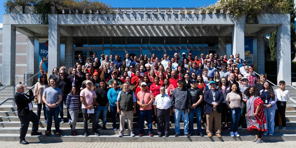 A group of employees standing on the front entrance steps of the Skirball building.