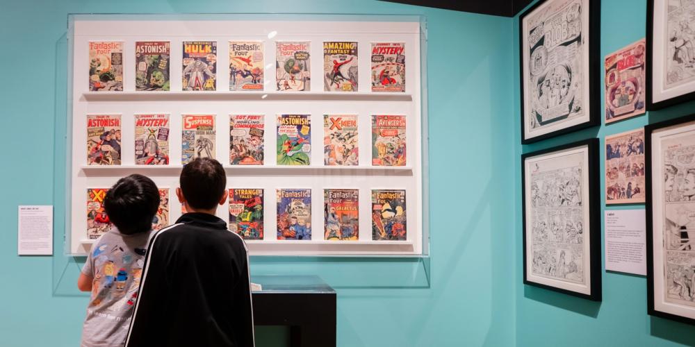 Two people view the exhibition Jack Kirby: Heroes and Humanity.